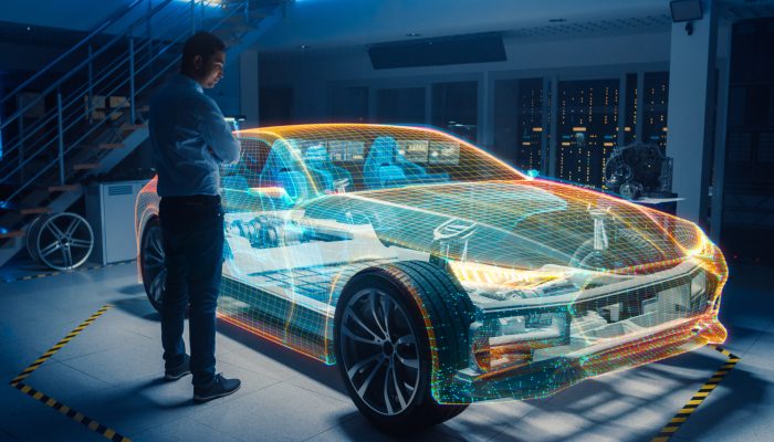 In Automotive Innovation Facility Automobile Design Engineer Working on 3D Holographic Model Projection of Electric Car. Futuristic Concept of Virtual and Augmented Realty Use. In Automotive Innovation Facility Automobile Design Engineer Working on 3D Holographic Model Projection of Electric Car. Futuristic Concept of Virtual and Augmented Realty Use.